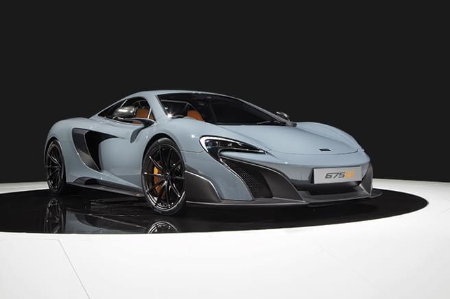Image d'une McLaren 675LT, supercar haute performance, avec détails en fibre de carbone et étriers de frein orange