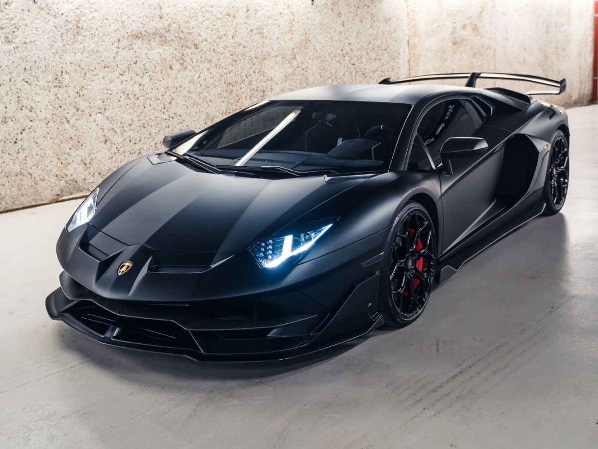 Photo d'une Lamborghini Aventador SVJ, design aérodynamique et futuriste, sur un fond neutre.