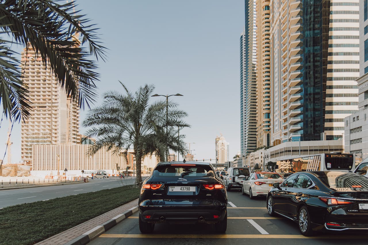 Dubai road traffic with modern skyscrapers and luxury cars in urban landscape.